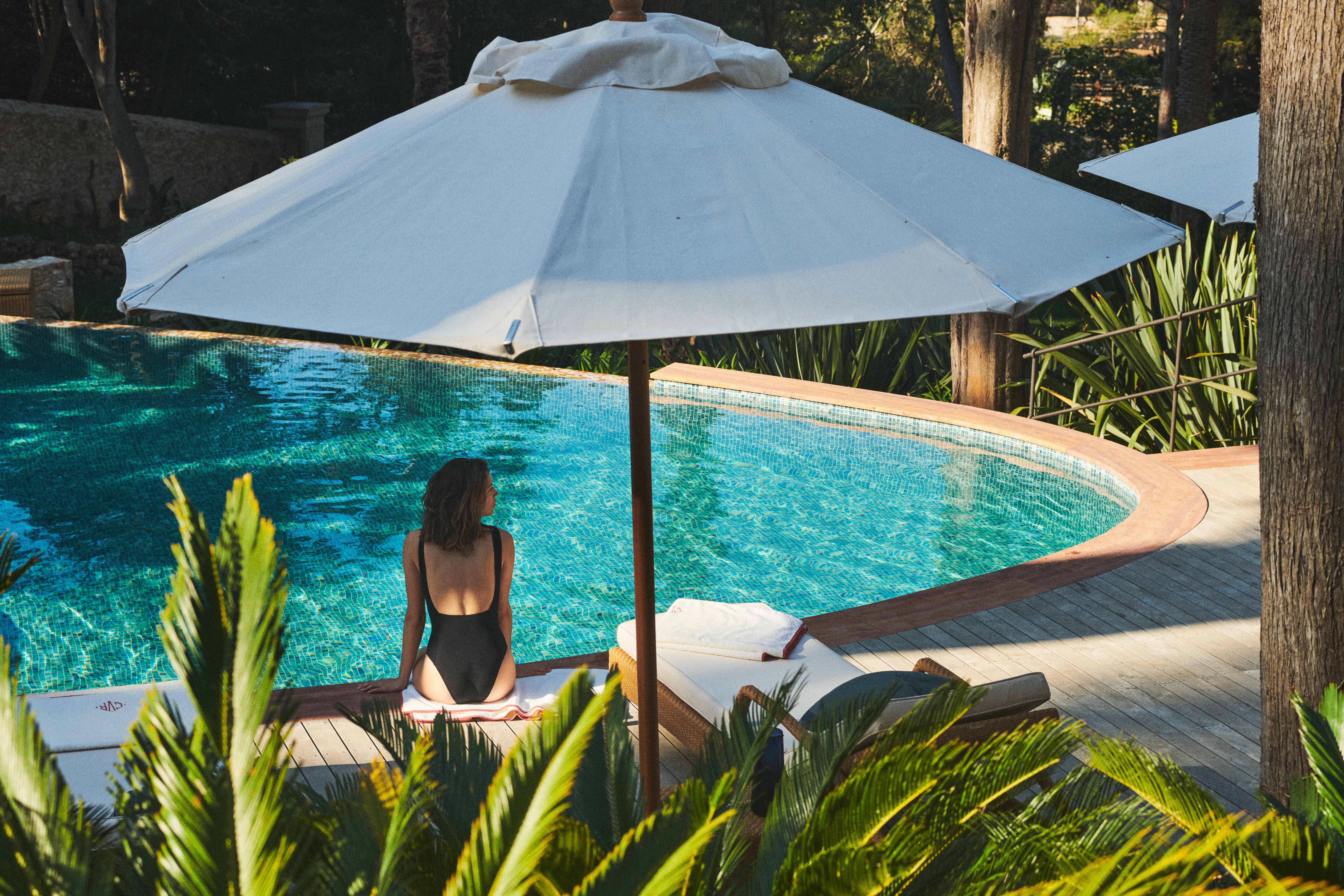 Luxury villa in Losinj with pool and woman sitting by the pool enjoying the vacation