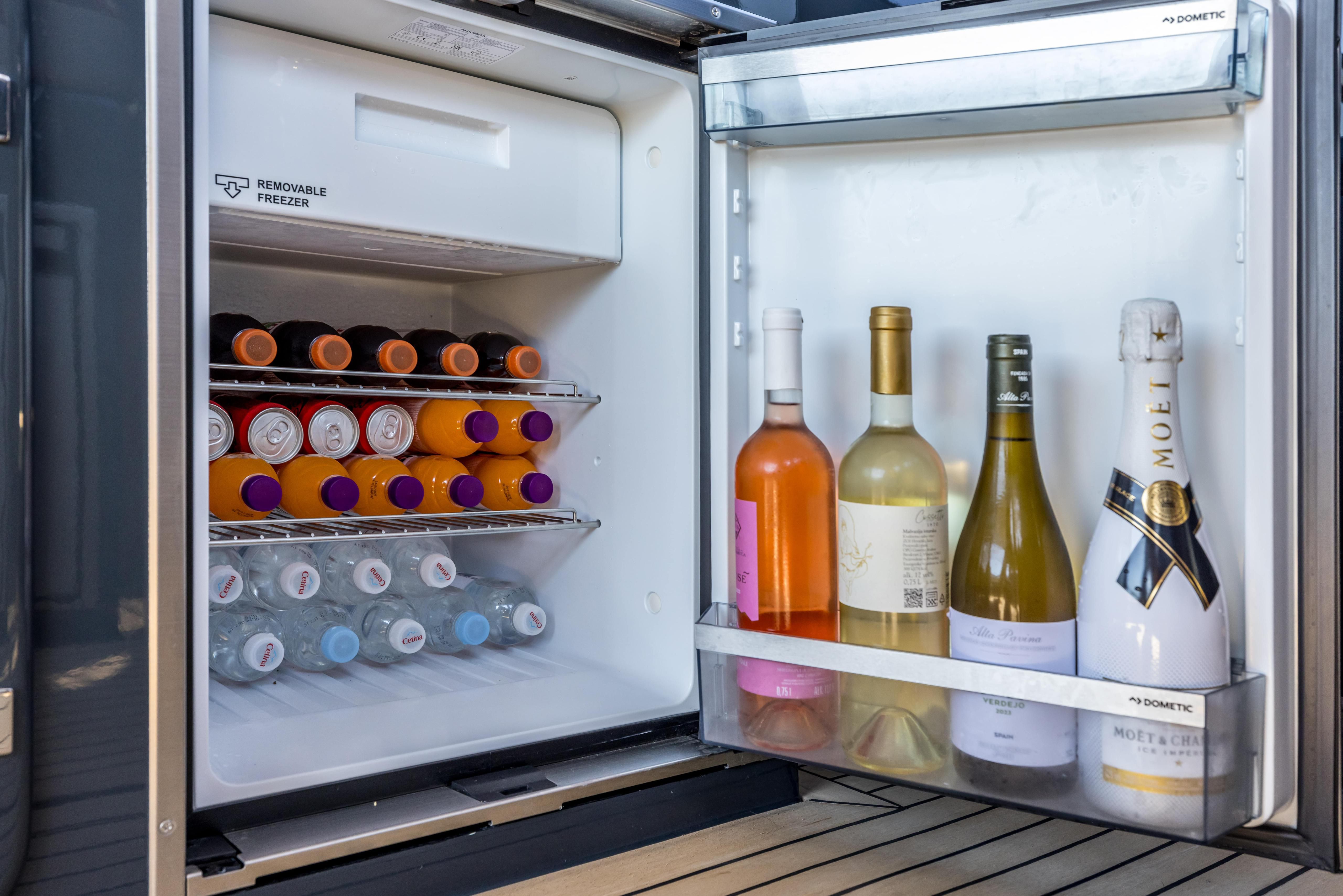 Open refrigerator on Colnago 45 displaying shelves filled with colorful drink bottles and various wines.