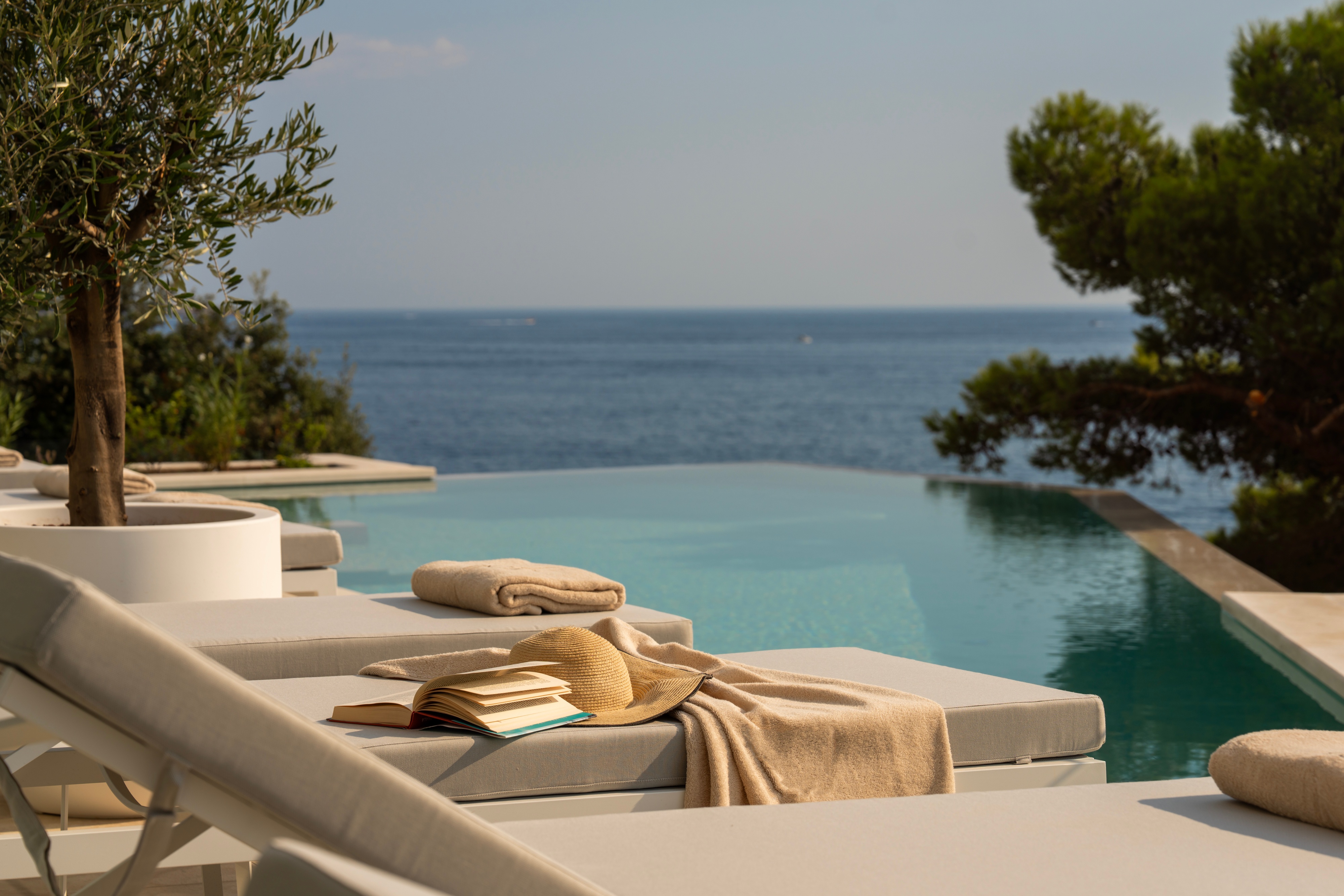 A serene swimming pool surrounded by lounge chairs and a stunning Adriatic view on a sunny day in a luxury villa in Croatia