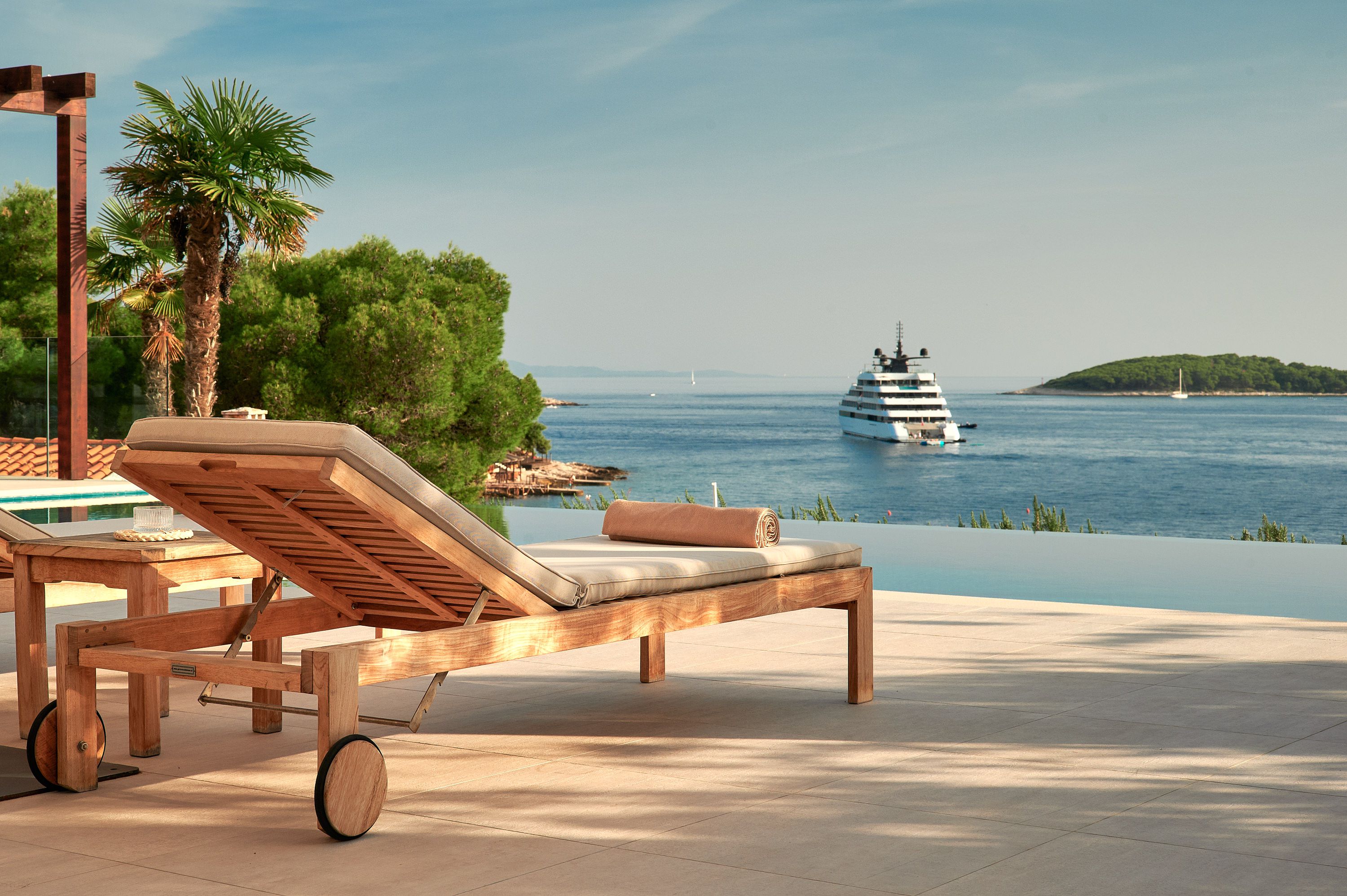 A stunning view of a pool at the luxury villa Sapphire Hvar, with a boat floating peacefully in the water