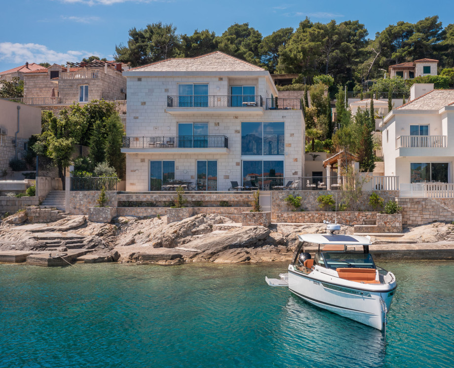 Stunning villa with an infinity swimming pool and a motor boat in the peaceful bay in front
