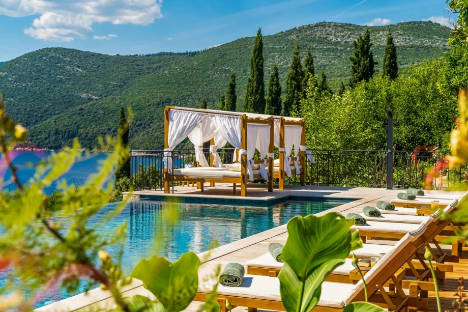A serene pool with lounge chairs and umbrellas, overlooking the sea at a private villa in Dubrovnik, Croatia