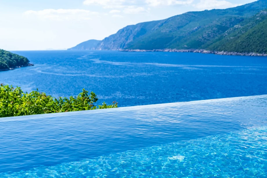 An infinity pool at a private villa in Dubrovnik, Croatia, offering a sea view, jacuzzi, and access to a private beach