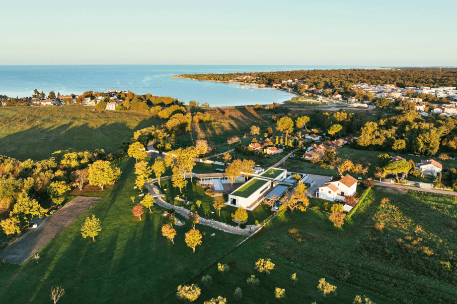 Aerial view of the luxury Villa Hacienda Istria villa with a heated pool, spa, and a sea view surrounded by garden.