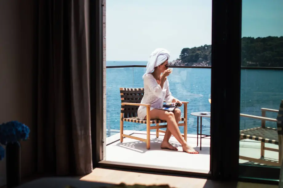 Woman enjoying coffee and Adriatic views on a balcony in a seafront private villa in Dubrovnik